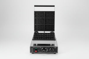 Waffle maker with waffles and berries on a white background