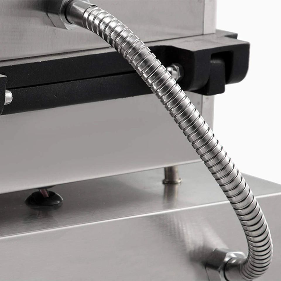 Metallic hose attached to a piece of industrial equipment on a gray background